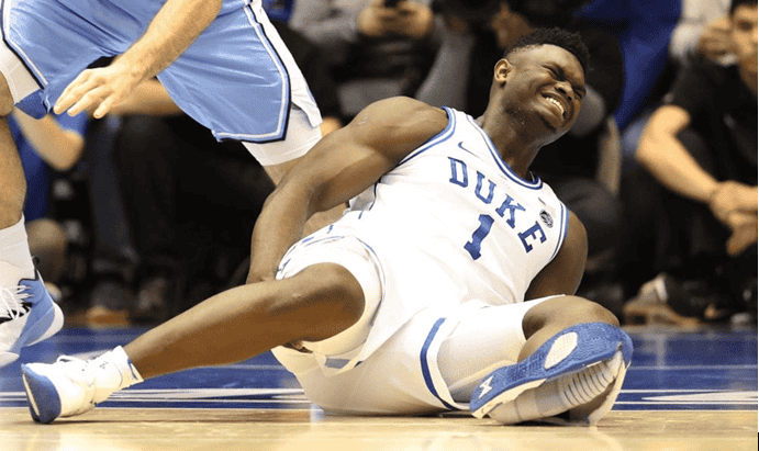 Basketball player falling to the court as his knee gives way