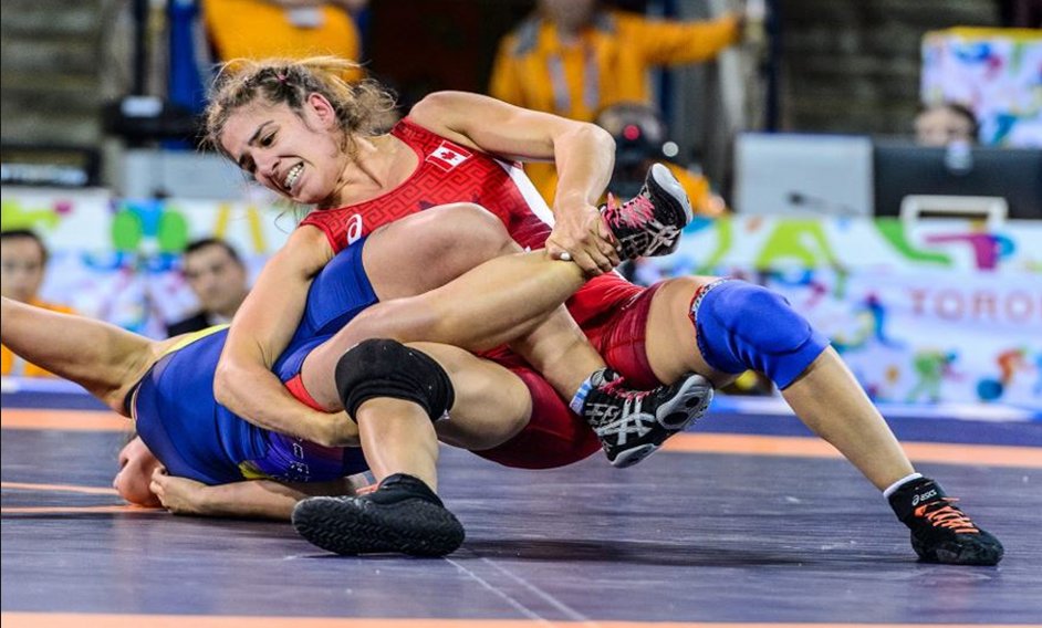 Two women wrestling on a mat, one gripping the other's leg