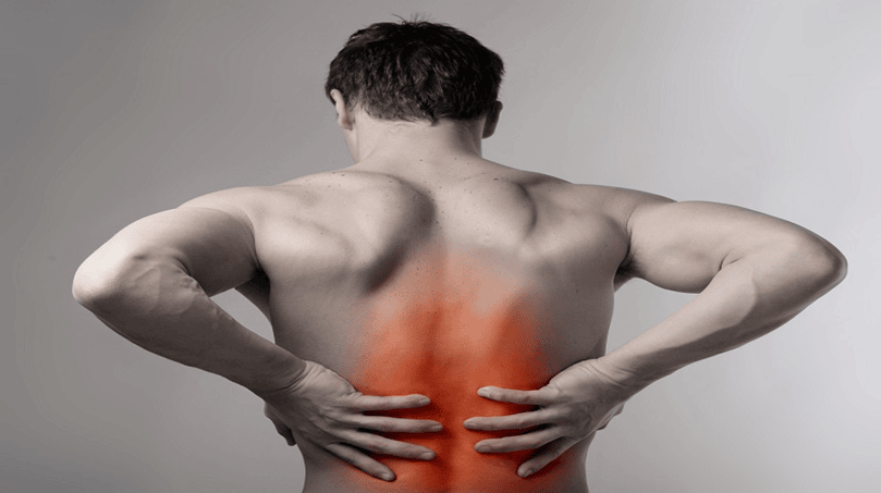 A shirtless man seen from behind, holding his lower back, with the painful area highlighted in red