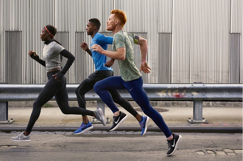 Three runners training together along a road