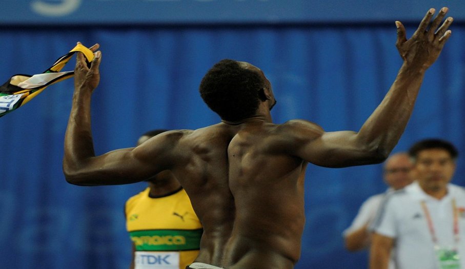 Sprinter celebrating with arms outstretched after a race