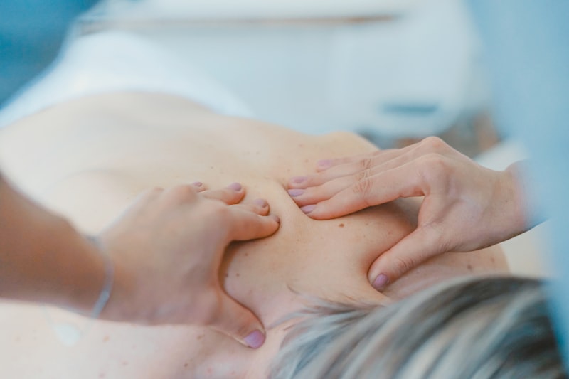 Therapist's hands working across a client's upper back during a deep tissue treatment